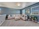 Cozy living room with carpet flooring, large windows, comfortable seating, and a stylish accent wall at 23957 E Rocky Top Ave, Aurora, CO 80016