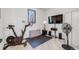 Home gym features a stationary bike, flat screen television, and hardwood floors at 2801 Lawrence St, Denver, CO 80205