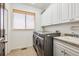 Bright laundry room with modern washer and dryer, with sink, and plenty of storage at 5375 Twilight Way, Parker, CO 80134