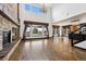 Open floor plan showcases large windows, hardwood floors, and stone fireplace leading to the kitchen at 5375 Twilight Way, Parker, CO 80134