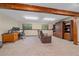 Basement with wood beams, built in shelving and desk, and brown leather seating at 8944 W 66Th Pl, Arvada, CO 80004