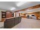 Finished basement boasts custom cabinets, sofa, and an open design for versatile use at 8944 W 66Th Pl, Arvada, CO 80004