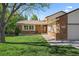 Well-kept home with manicured lawn, brick details, and a welcoming front entrance at 8944 W 66Th Pl, Arvada, CO 80004