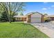 Charming home with a brick facade, lush lawn, and a well-maintained landscape at 8944 W 66Th Pl, Arvada, CO 80004