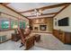 Cozy living room features a wood-burning fireplace and wood-beamed ceilings at 8944 W 66Th Pl, Arvada, CO 80004