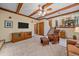 Spacious living room showcasing wood beams, a TV, and staircase access at 8944 W 66Th Pl, Arvada, CO 80004