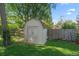 Backyard shed with double doors, offering ample storage space in a well-maintained yard with mature trees at 8944 W 66Th Pl, Arvada, CO 80004