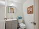 Charming bathroom with grey vanity, toilet with blue towel, and decorative art at 4634 S Adobe Ct, Littleton, CO 80127