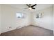 Bright bedroom featuring neutral carpet, two windows, and a ceiling fan at 4634 S Adobe Ct, Littleton, CO 80127