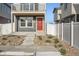 Two-story home with a small front-facing balcony and a vibrant red front door at 5035 N Walden Way, Denver, CO 80249