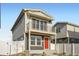 Charming two-story home with a balcony and a red front door with manicured landscaping at 5035 N Walden Way, Denver, CO 80249