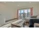 Bright living room with access to balcony, wood floors, and comfortable seating at 5035 N Walden Way, Denver, CO 80249