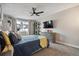 Cozy bedroom featuring a ceiling fan, TV, dresser, and a sun-filled window view at 7755 E Quincy # 201, Denver, CO 80237