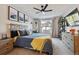 Bright bedroom featuring a ceiling fan, mounted TV, and window with natural light at 7755 E Quincy # 201, Denver, CO 80237