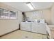 Convenient laundry room with multiple washers, dryers, and a utility sink at 7755 E Quincy # 201, Denver, CO 80237