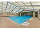 Bright indoor pool with awning-style skylights, metal railing, and easy access to the pool deck at 7755 E Quincy # 201, Denver, CO 80237