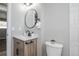 Elegant bathroom features a wood vanity with a marble countertop and a round mirror at 4933 W 61St Ave, Arvada, CO 80003