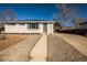 Charming single story home with a manicured yard, a cozy exterior, and a well-lit walkway at 4933 W 61St Ave, Arvada, CO 80003