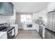 Modern kitchen featuring stainless steel appliances, updated white cabinetry, and a well-lit workspace at 4933 W 61St Ave, Arvada, CO 80003