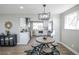 Modern eat-in kitchen featuring a dining table with seating, stainless steel appliances, and bright natural light at 4933 W 61St Ave, Arvada, CO 80003