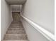 Carpeted staircase with a white handrail leading to the basement of the house at 4933 W 61St Ave, Arvada, CO 80003