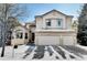 Two-story house with three-car garage and snowy front yard at 5799 S Depew Cir, Littleton, CO 80123