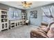 Cozy living room with natural light, plush carpet, decorative shelving, and comfortable seating at 11569 Grape St, Thornton, CO 80233