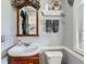 Cozy powder room featuring a classic pedestal sink, decorative mirror, and neutral color palette at 11569 Grape St, Thornton, CO 80233