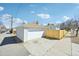 A detached one car garage with a new wooden fence under a blue sky at 2295 S Sherman St, Denver, CO 80210