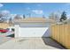 Two-car garage with white panel doors, a light brown roof and a concrete driveway at 2295 S Sherman St, Denver, CO 80210