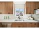 A close-up of the stylish kitchen sink featuring wood cabinets, white countertops, and a subway tile backsplash at 2295 S Sherman St, Denver, CO 80210