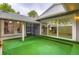 Backyard oasis with artificial grass, patio, and glass sliding doors to interior at 10295 E Evans Ave # 114, Aurora, CO 80247