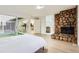 Bedroom showcasing stone fireplace, large glass slider to outdoor area, and pass-through to bathroom at 10295 E Evans Ave # 114, Aurora, CO 80247