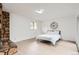 Bedroom featuring stone fireplace, slider to outdoor area and bright natural light from window at 10295 E Evans Ave # 114, Aurora, CO 80247