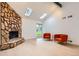 Bright living room featuring a stone fireplace, skylights, and vaulted ceilings at 10295 E Evans Ave # 114, Aurora, CO 80247