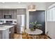 Open kitchen and dining area with stainless steel appliances and modern table and chairs at 1277 Quitman St, Denver, CO 80204