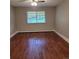 Simple bedroom with hardwood floors, a bright window providing ample natural light, and classic baseboard trim at 9300 E Center Ave # 6A, Denver, CO 80247