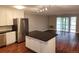 Bright kitchen with an island, stainless steel appliances, and wooden floors that flow into an inviting living space at 9300 E Center Ave # 6A, Denver, CO 80247