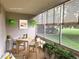 Cozy sunroom with a dining setup, large windows overlooking the green landscape, and plant decor for a serene space at 9300 E Center Ave # 6A, Denver, CO 80247