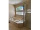 Bathroom featuring a soaking tub, glass block window, and shower at 20304 E 47Th Pl, Denver, CO 80249