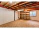 Unfinished basement features wood flooring, bright light, and shelving unit at 495 Bexley St, Highlands Ranch, CO 80126