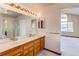 Bathroom with double sink vanity with Hollywood lighting and glass shower at 495 Bexley St, Highlands Ranch, CO 80126