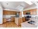 An open kitchen has an island, granite counter tops, stainless steel appliances and light wood cabinets at 495 Bexley St, Highlands Ranch, CO 80126