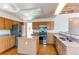 This kitchen has a large island with granite counter tops, light wood cabinets, and stainless steel appliances at 495 Bexley St, Highlands Ranch, CO 80126