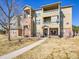 Charming multi-story exterior with attractive brick accents and landscaped front entrance walkway at 12768 Ironstone Way # 204, Parker, CO 80134