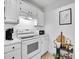 Well-lit kitchen with white cabinetry, modern appliances, and marble counters offering a sleek and functional cooking space at 12768 Ironstone Way # 204, Parker, CO 80134