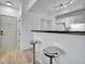 Kitchen area with bar seating, white cabinets, and modern appliances near entry and hallway at 12768 Ironstone Way # 204, Parker, CO 80134