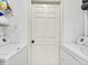 Functional laundry area with a white door, a white washer, dryer and shelving for convenient storage at 12768 Ironstone Way # 204, Parker, CO 80134