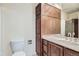 Bathroom featuring wood cabinets, a vanity with sink, and a toilet at 2122 S Victor St # F, Aurora, CO 80014