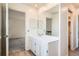 Bright bathroom features a vanity with a sink, a mirror, and a door to a bedroom at 2122 S Victor St # F, Aurora, CO 80014